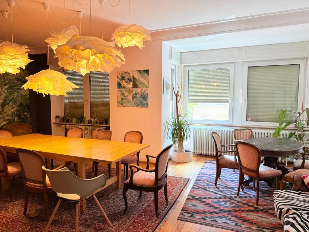 Esszimmer mit langem Tisch, an dem Gäste zusammen essen